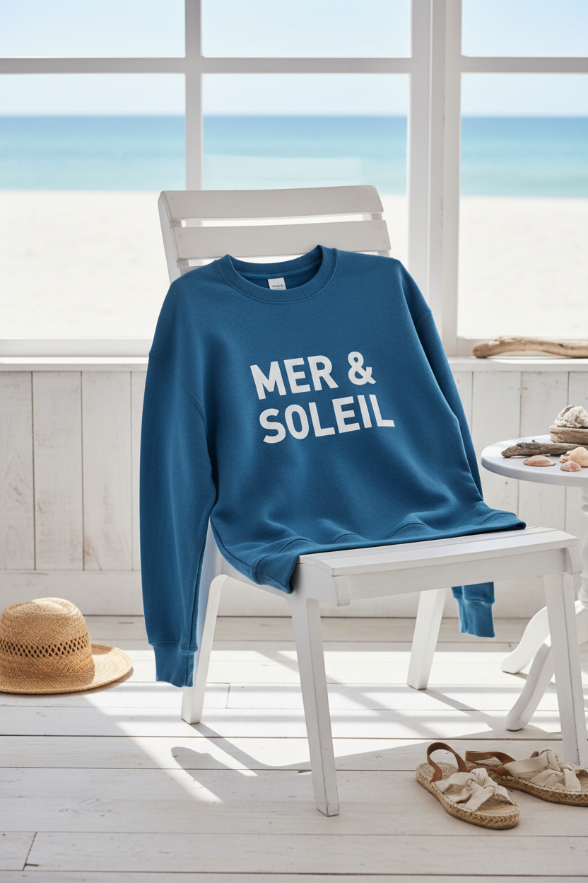Sweat Mer & Soleil déposé sur chaise blanche beach house